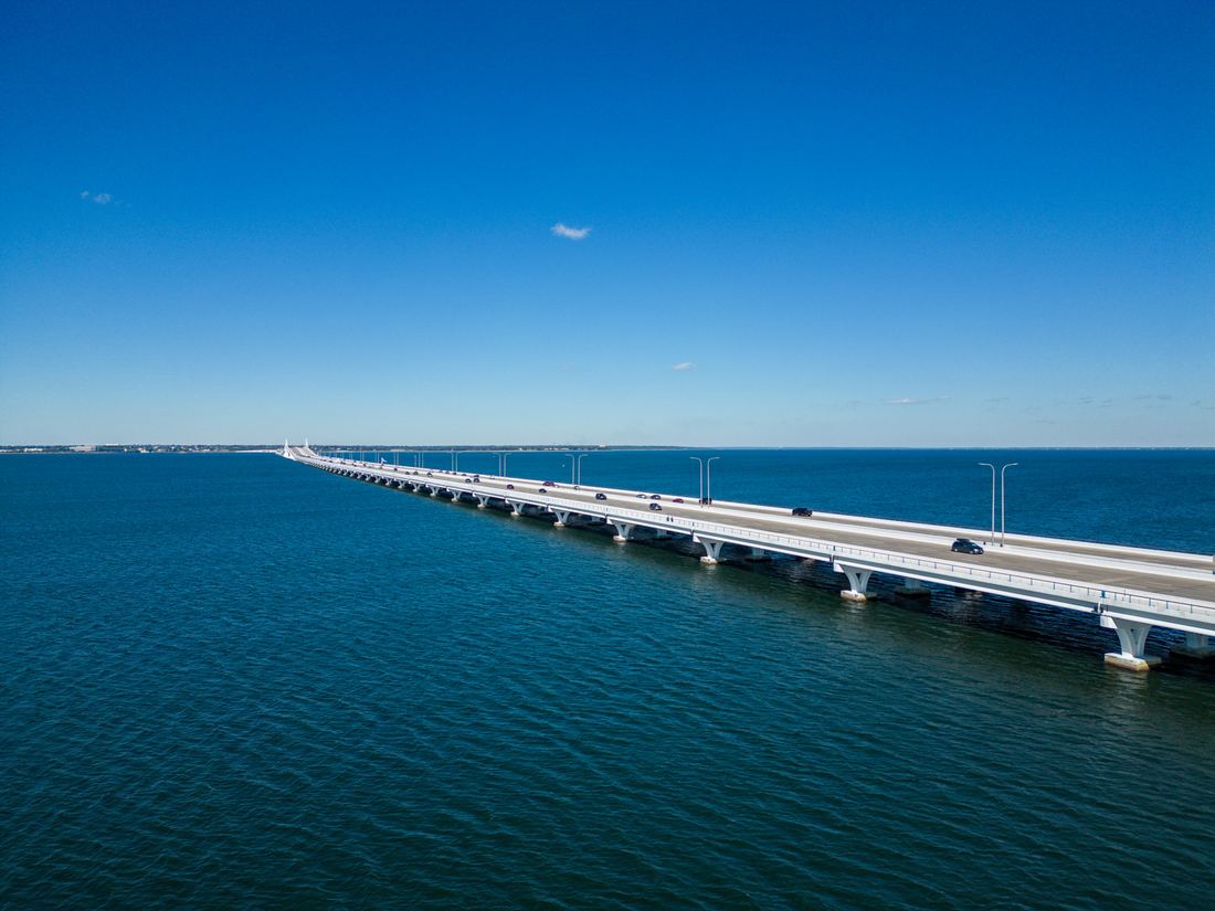 Long highway bridge crossing deep blue Pensacola Bay under a clear sky