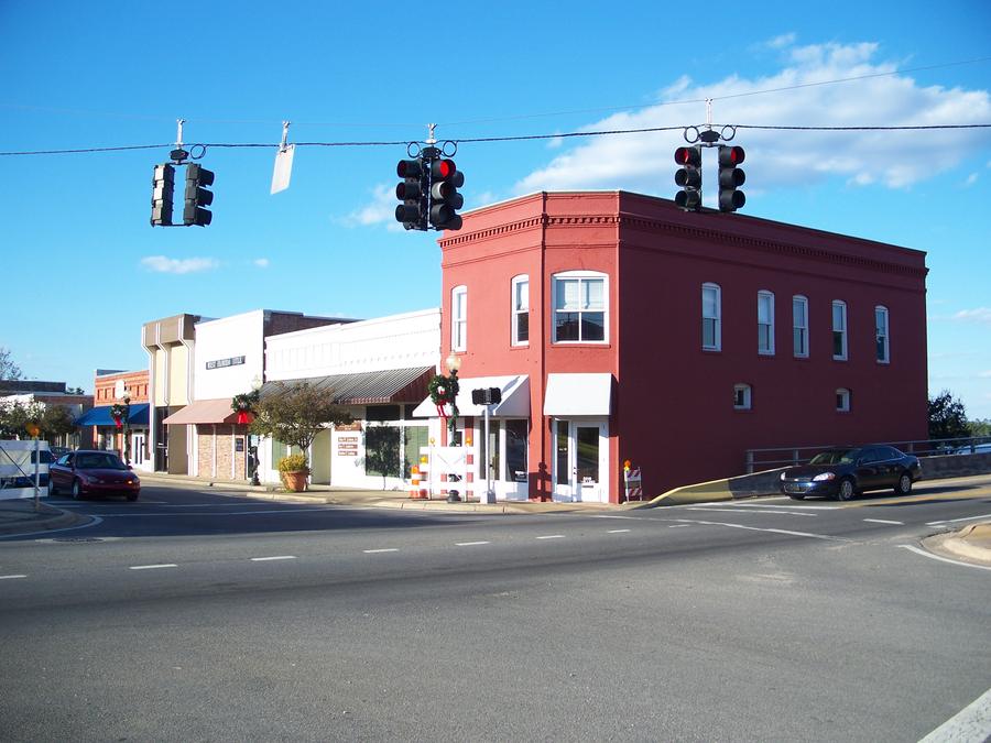 Red brick historic building at a downtown intersection under blue sky in Milton, Florida